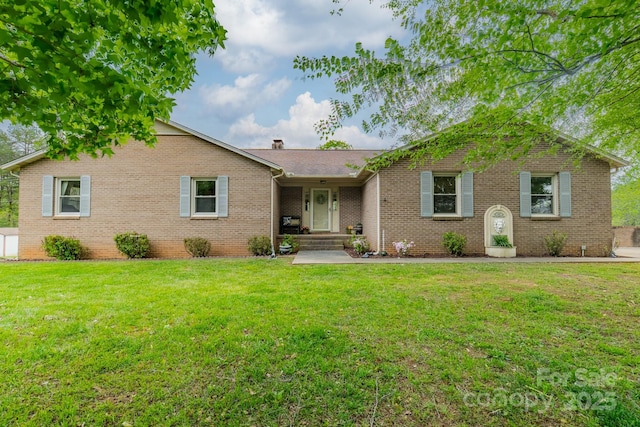 ranch-style home with a front lawn, brick siding, and a chimney