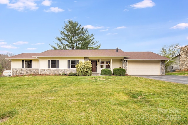 ranch-style home featuring stone siding, a front lawn, aphalt driveway, and an attached garage