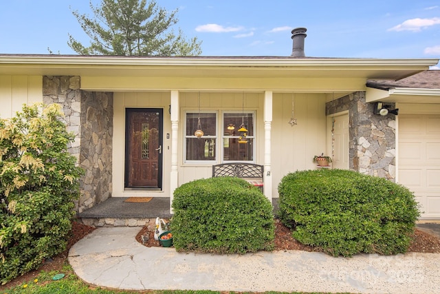 property entrance with an attached garage, stone siding, board and batten siding, and a porch