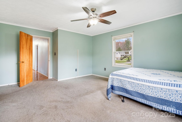 carpeted bedroom with a ceiling fan, ornamental molding, and baseboards