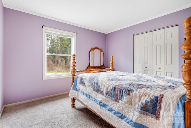 carpeted bedroom with ornamental molding, baseboards, and a closet