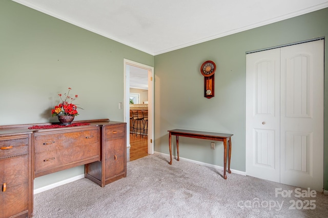 bedroom featuring baseboards, ornamental molding, a closet, and carpet