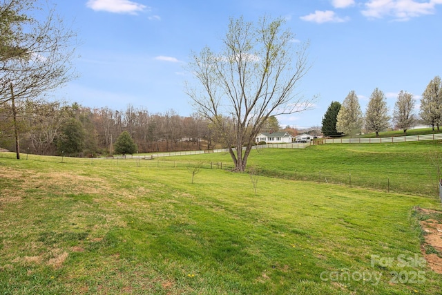 view of yard featuring fence and a rural view