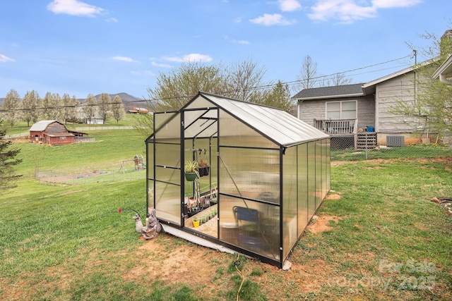 view of greenhouse featuring a lawn