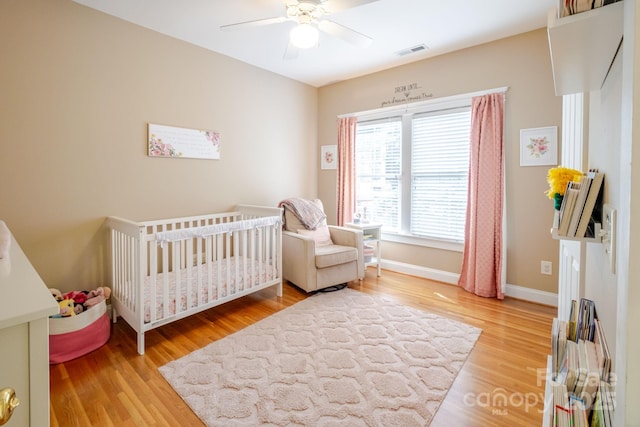 734 E 10th St, Charlotte, NC 28202 - bedroom featuring a crib, ceiling fan, light wood finished floors, baseboards, and visible vents