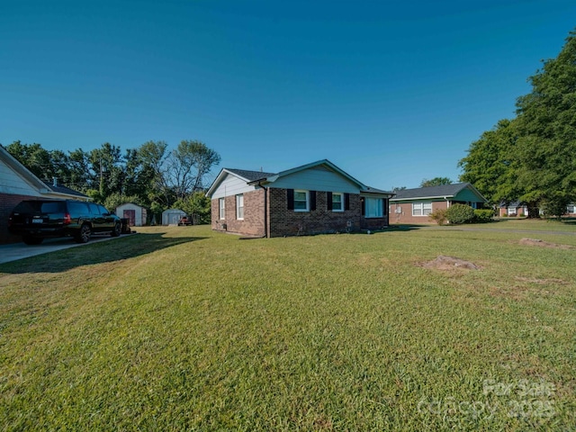 view of home's exterior with a storage shed, a lawn, brick siding, and an outbuilding