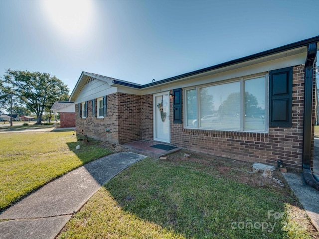 ranch-style house featuring brick siding and a front lawn