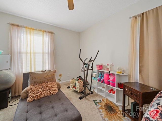 game room with carpet floors, ceiling fan, and a textured ceiling