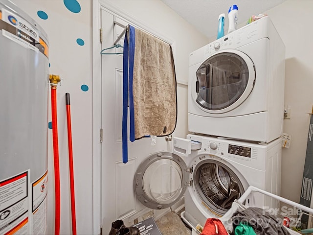 laundry area featuring stacked washing machine and dryer and water heater