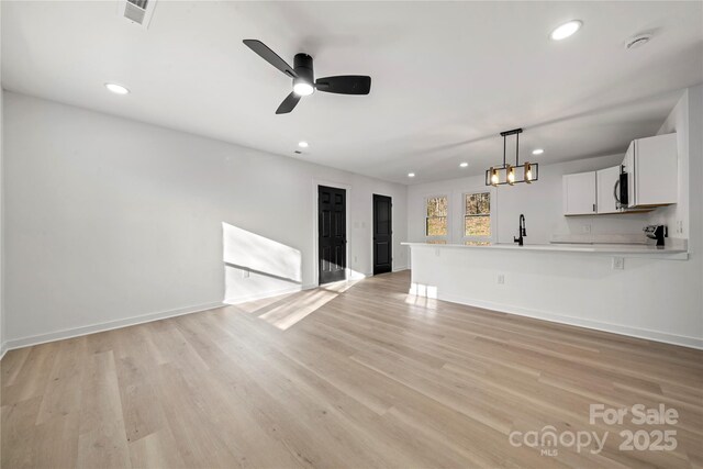 2120 Green Oak Dr, Shelby, NC 28152 - unfurnished living room featuring recessed lighting, baseboards, light wood-style flooring, a ceiling fan, and a sink