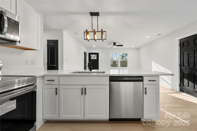 2120 Green Oak Dr, Shelby, NC 28152 - kitchen with appliances with stainless steel finishes, a sink, a peninsula, light countertops, and pendant lighting