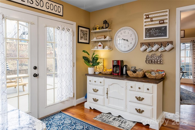 entryway with wood finished floors, baseboards, and french doors