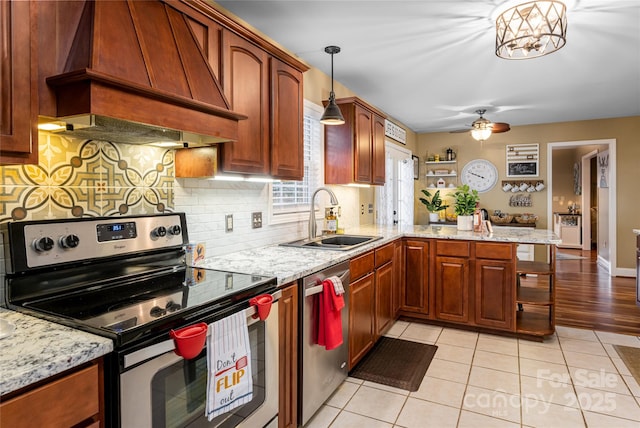 kitchen featuring appliances with stainless steel finishes, custom exhaust hood, a sink, a peninsula, and tasteful backsplash