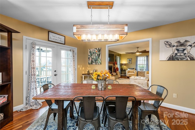 dining area featuring baseboards, wood finished floors, ceiling fan, and french doors
