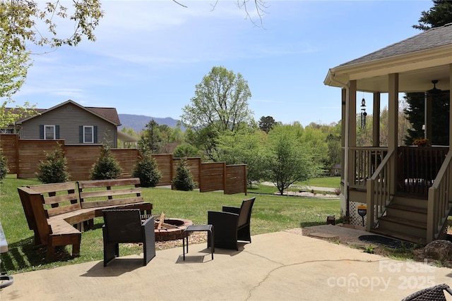view of patio / terrace with a fire pit and a mountain view