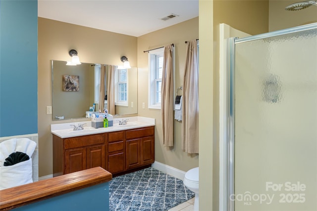 bathroom featuring a shower stall, double vanity, tile patterned flooring, toilet, and baseboards