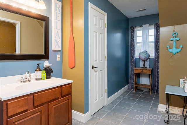 bathroom with tile patterned floors, baseboards, and vanity