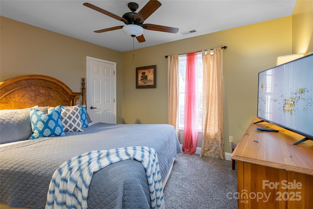 carpeted bedroom with ceiling fan and baseboards