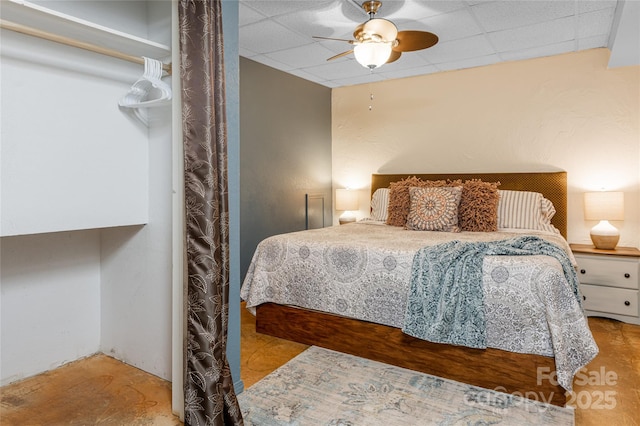 bedroom with a drop ceiling and ceiling fan