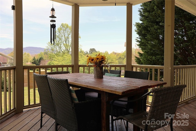 wooden terrace with a mountain view and outdoor dining area