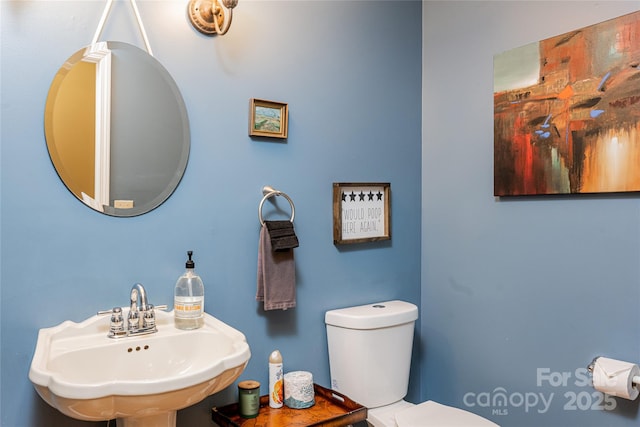 half bath featuring a sink and toilet