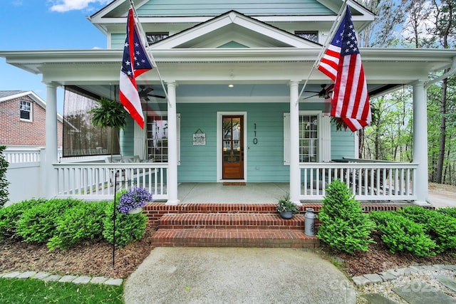 doorway to property with a porch and fence
