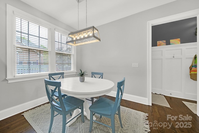 dining area with baseboards, a chandelier, and wood finished floors