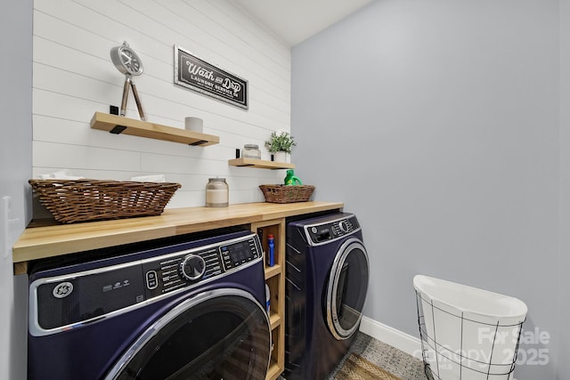 washroom with baseboards, washing machine and dryer, and laundry area