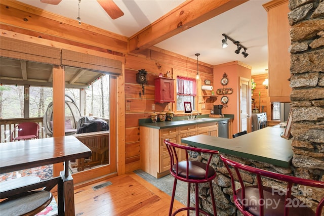 kitchen with a healthy amount of sunlight, washing machine and clothes dryer, a sink, and dishwasher