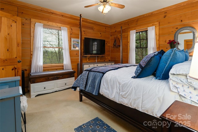 bedroom featuring wooden walls, carpet floors, and ceiling fan
