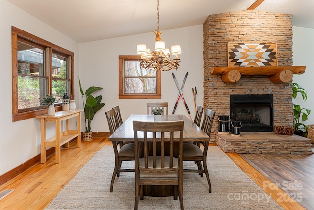 39 Antler Springs Way, Maggie Valley, NC 28751 - dining area featuring lofted ceiling, light wood-style flooring, a chandelier, baseboards, and a fireplace