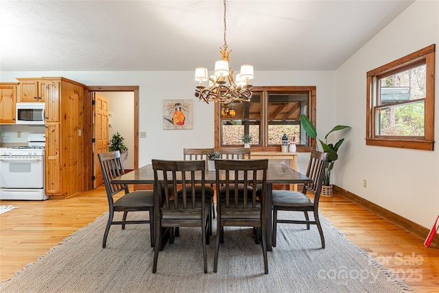 39 Antler Springs Way, Maggie Valley, NC 28751 - dining area with a chandelier, light wood-style floors, and baseboards
