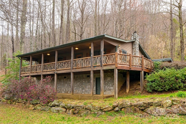 39 Antler Springs Way, Maggie Valley, NC 28751 - back of property with a chimney, stone siding, a view of trees, and a wooden deck