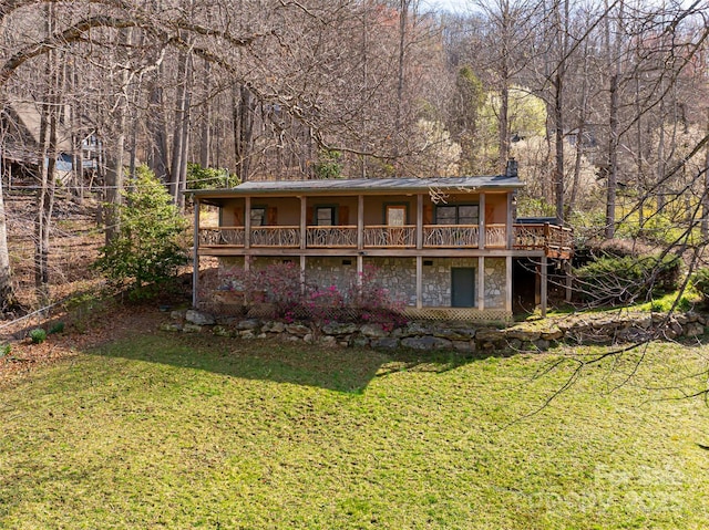 39 Antler Springs Way, Maggie Valley, NC 28751 - back of property featuring stone siding, a chimney, a lawn, a wooded view, and a deck