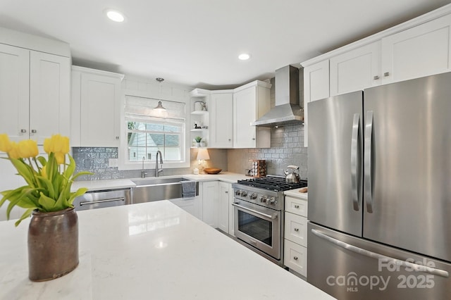 kitchen featuring open shelves, wall chimney exhaust hood, white cabinets, a sink, and appliances with stainless steel finishes