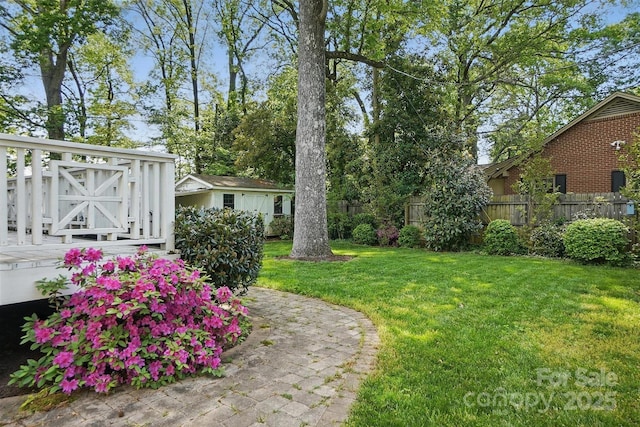 view of yard with fence and an outbuilding