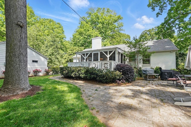 5400 Glenham Dr, Charlotte, NC 28210 - back of house with a chimney, a patio area, a lawn, a wooden deck, and brick siding
