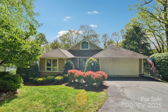 view of front of house featuring a shingled roof, a front lawn, driveway, and a garage