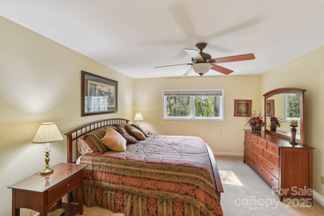 bedroom with light carpet, a ceiling fan, and baseboards