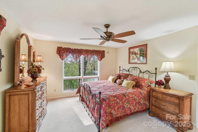 bedroom featuring light carpet, baseboards, and ceiling fan