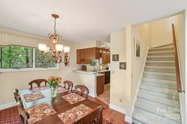 dining room featuring stairway, light wood-style flooring, a chandelier, and plenty of natural light