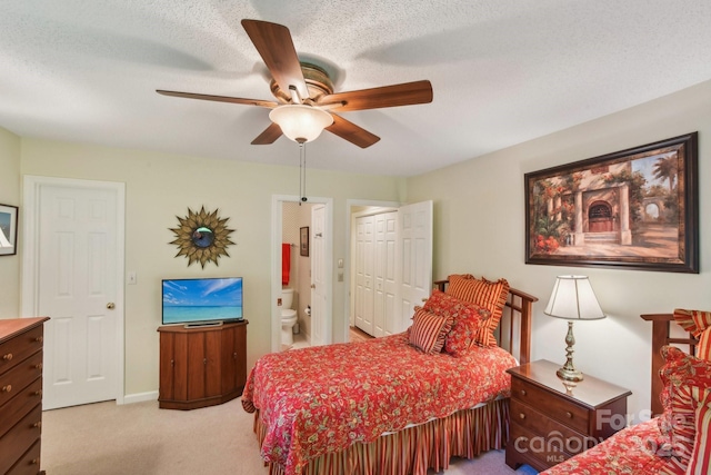 bedroom with ceiling fan, ensuite bath, a closet, and light colored carpet