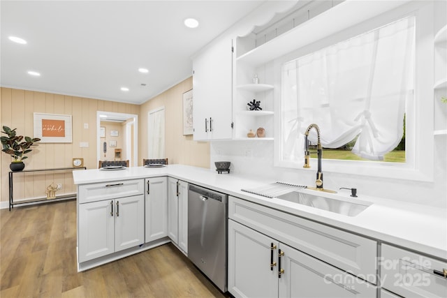kitchen featuring open shelves, dishwasher, a sink, light countertops, and a peninsula