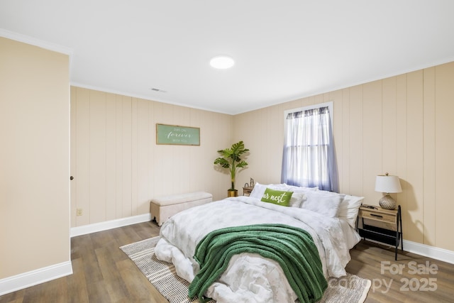 bedroom featuring baseboards and wood finished floors
