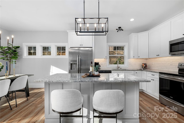 9849 Rich Hatchet Rd, Huntersville, NC 28078 - kitchen with a sink, tasteful backsplash, wood finished floors, a kitchen bar, and stainless steel appliances