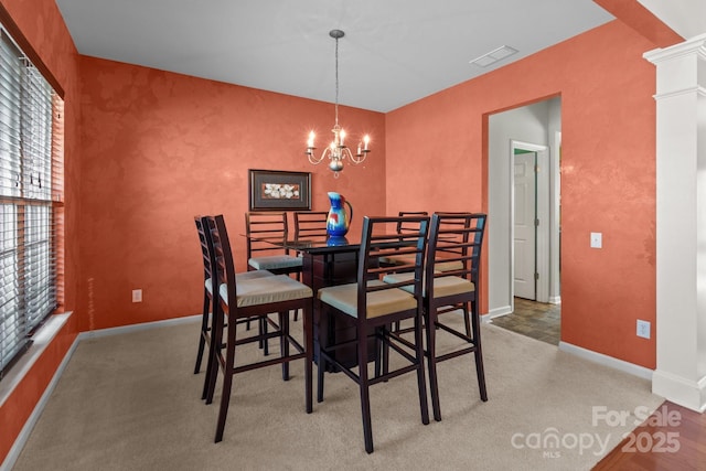 dining room with visible vents, baseboards, an accent wall, an inviting chandelier, and light colored carpet