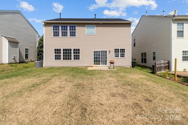 rear view of house featuring cooling unit, a patio area, and a lawn