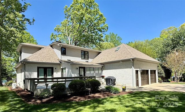 back of property with brick siding, an attached garage, driveway, and a shingled roof
