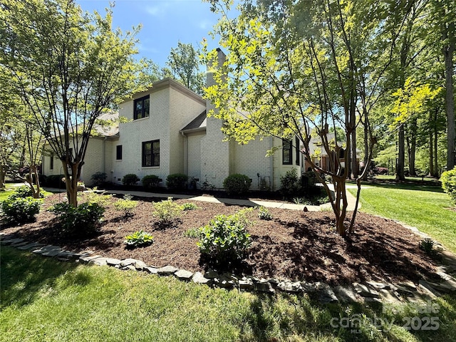view of front of property featuring a front lawn and brick siding