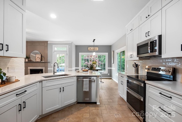 1214 Foxfield Rd, Waxhaw, NC 28173 - kitchen featuring appliances with stainless steel finishes, a sink, a peninsula, tasteful backsplash, and light countertops